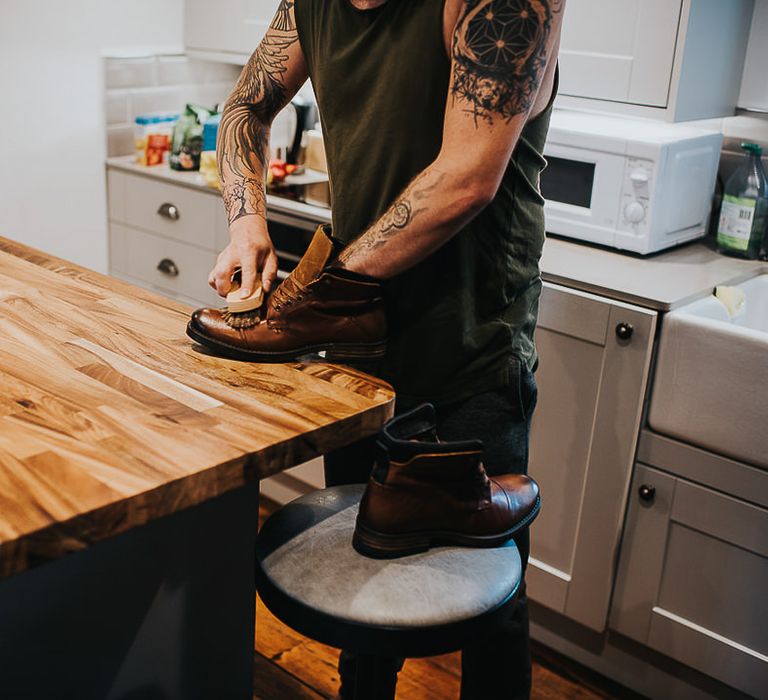 Groom cleans boots on the morning of his wedding