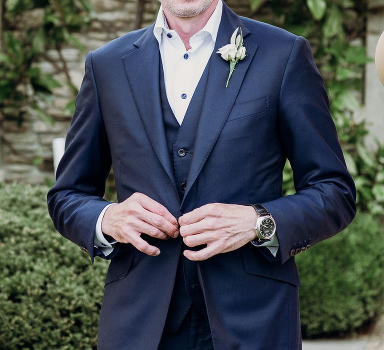 Smiling groom in navy Cad & the Dandy three piece suit with whit rose buttonhole