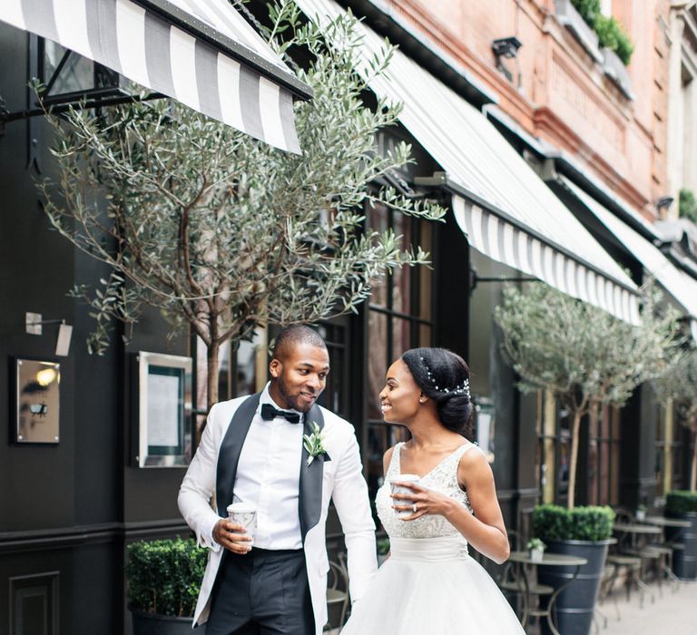 Bride & groom walk through the streets of London wedding monochrome tux and wedding gown