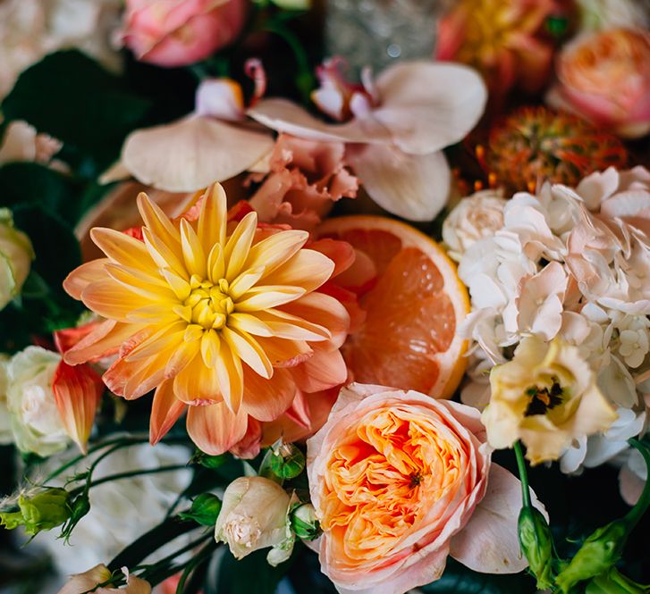 Peach yellow and white wedding flowers with cirrus fruit centerpiece 