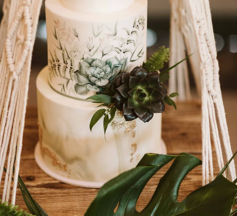 3-tiered wedding cake featuring green floral design and decor