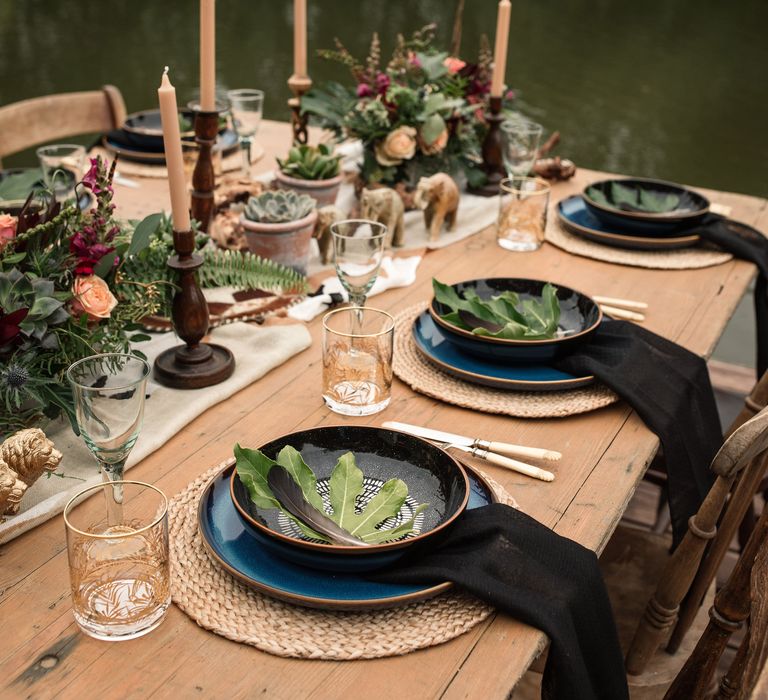 Wooden table featuring black table decor and camouflage table runner