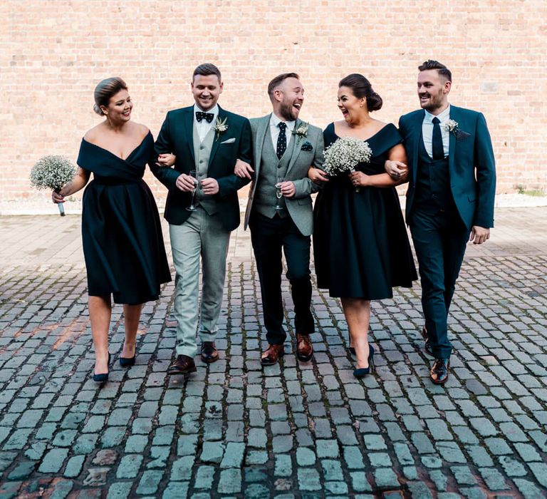 A mixed gender wedding party with two grooms. The bridesmaids are wearing short off the shoulder vintage style navy bridesmaid dresses | ASOS Dresses | Amy Faith Photography