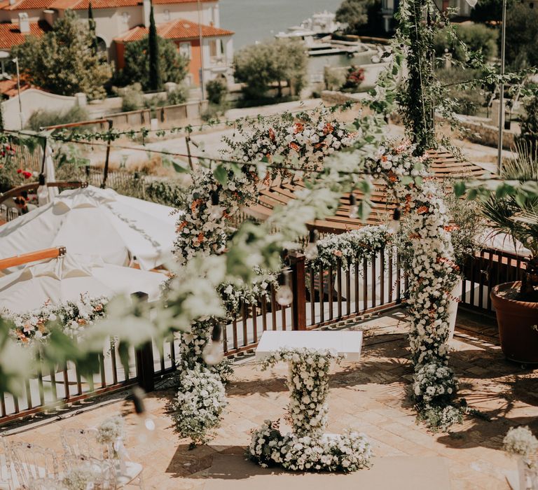 Huge white flower arch with a floral altar podium for outdoor Turkish wedding