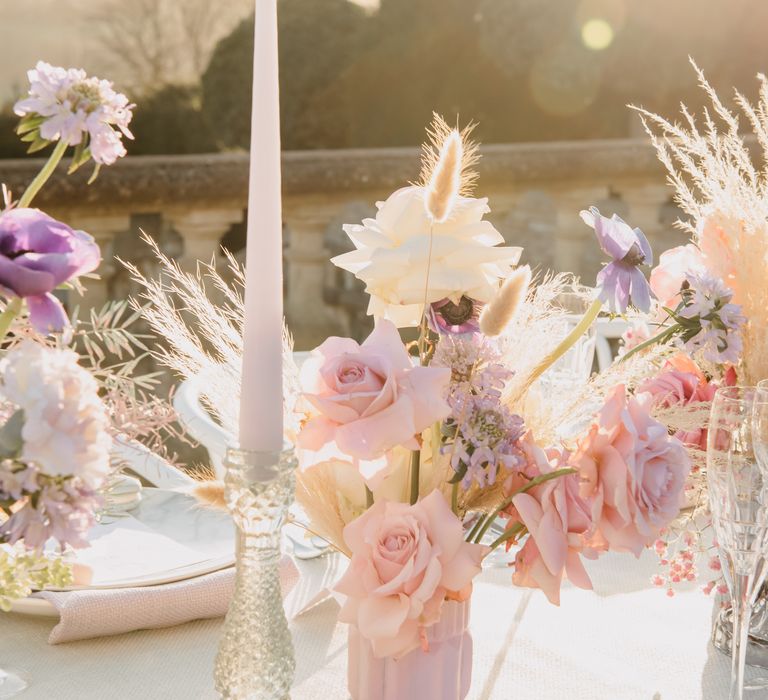 Golden hour tablescape with white candles and pastel floral decor