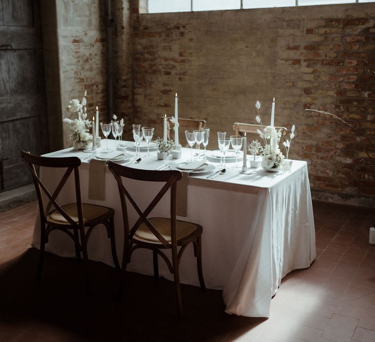 Minimalist decor for a simple elegant wedding table including dried grasses, bunny tails and white ceramics.