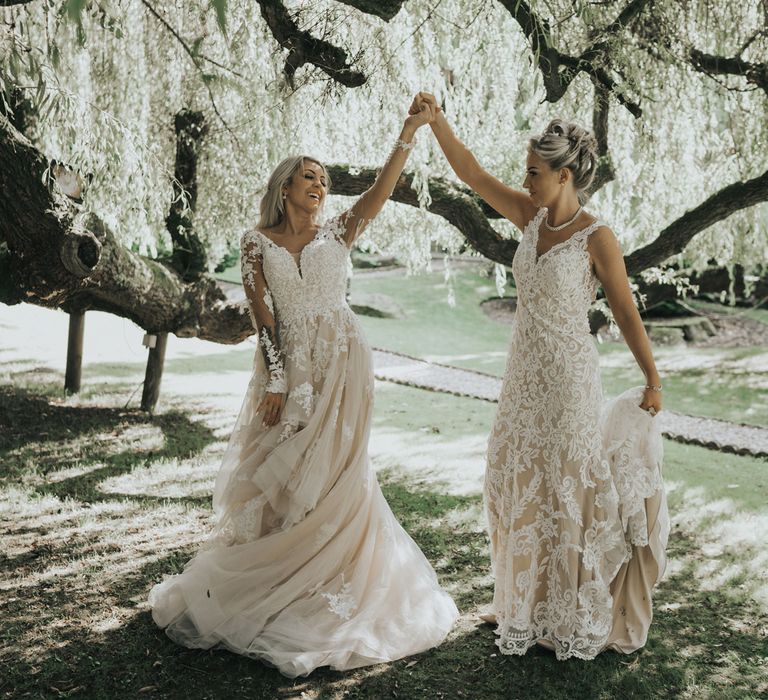 Two brides dance under the trees at Crab & Lobster fairytale wedding.