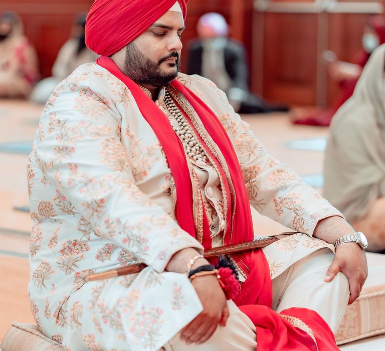 Groom sits cross legged on the day of his wedding