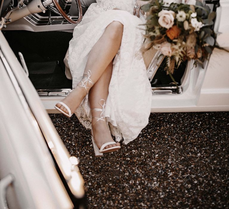 Stylish bride and groom portrait in a white mustang wedding car 