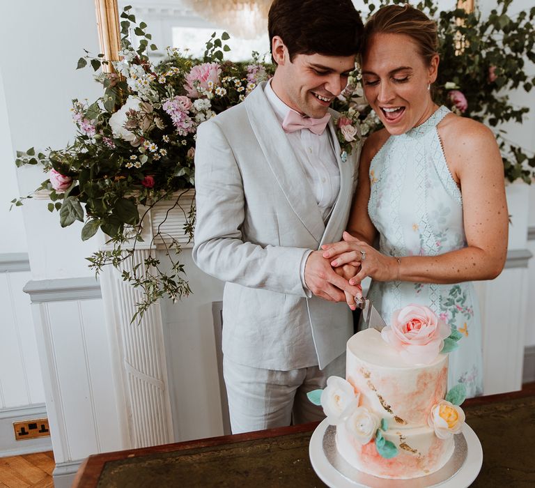 Bride & groom cut their wedding cake on the day of their wedding day