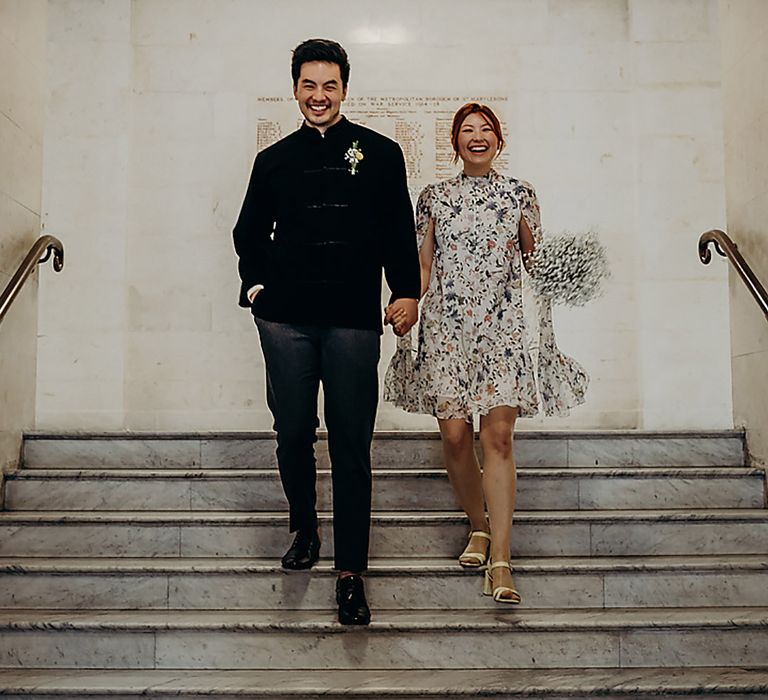 Bride and groom exiting their registry office wedding with the bride holding a gypsophila wedding bouquet 