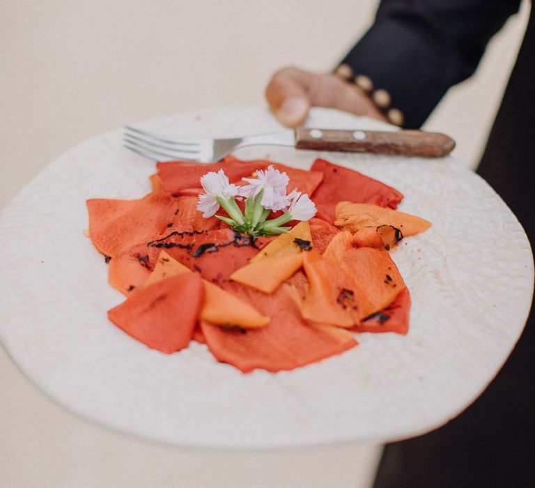 Orange roasted vegetables complete with white floral decoration