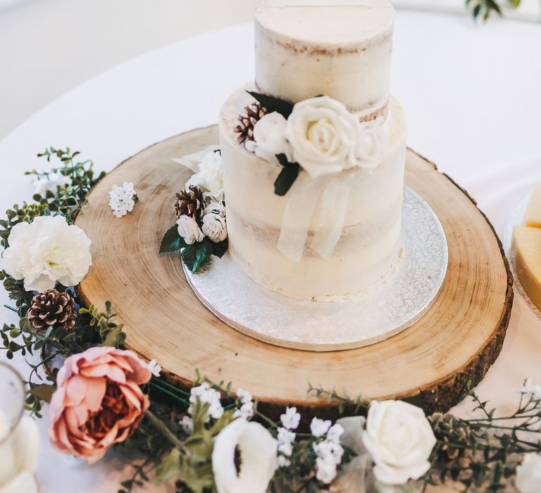 Semi naked wedding cake on a wooden tree slice with acrylic cake topper 