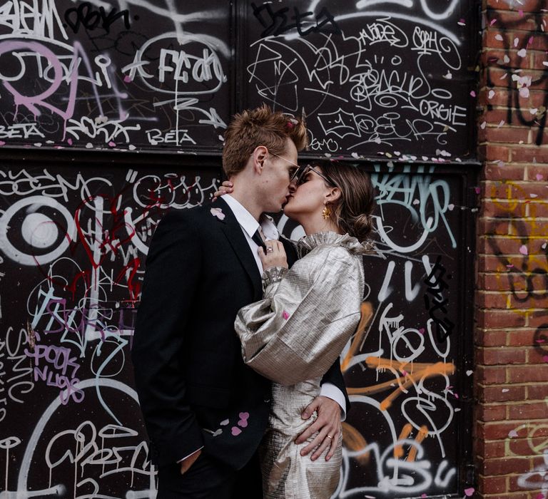 Bride and Groom kissing in front of urban graffiti wall industrial wedding