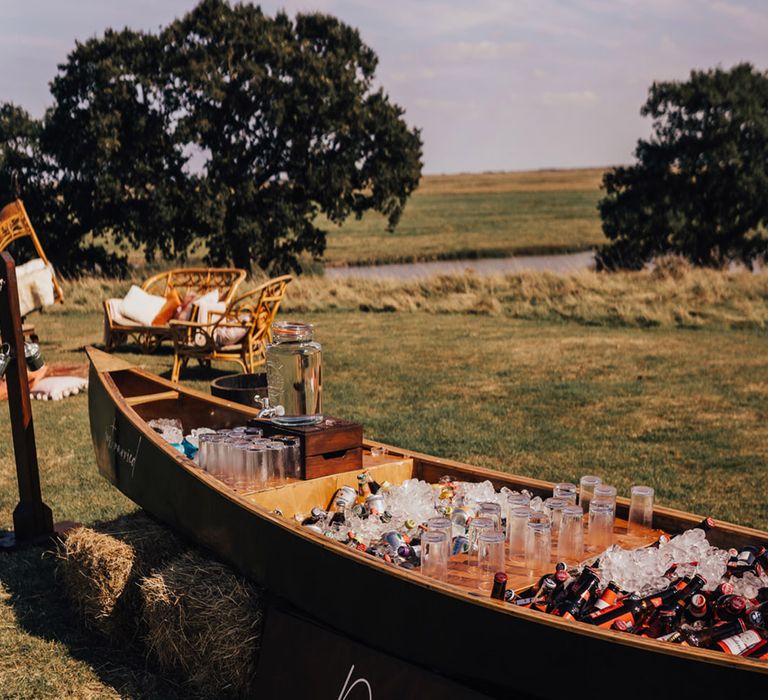 Quirky wooden boat with refreshments for wedding guests at Boho wedding 