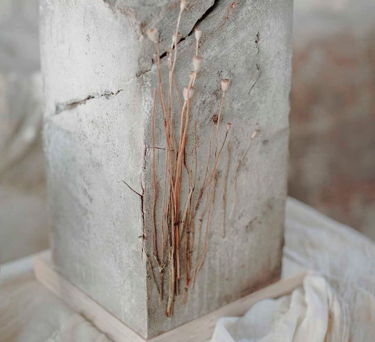 Square tall concrete wedding cake with dried flower stem decor 