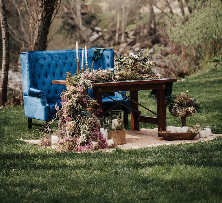 boho wedding elopement with sweetheart table decorated in wildflowers with a blue velvet love seat 