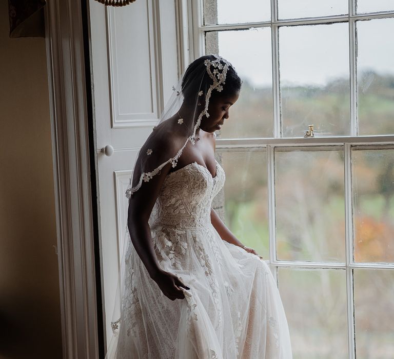 Beautiful Black bride wears detailed sweetheart wedding dress with lace edge veil