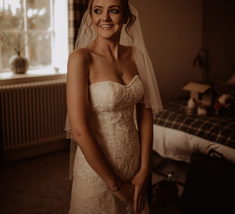 Brown haired bride on the day of her wedding wearing sweetheart neckline gown