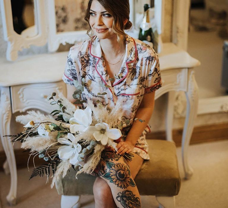 Beautiful bride clutches large pampas grass and white flower bouquet