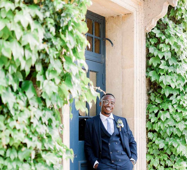 Groom wears three piece suit complete with pastel blue tie 