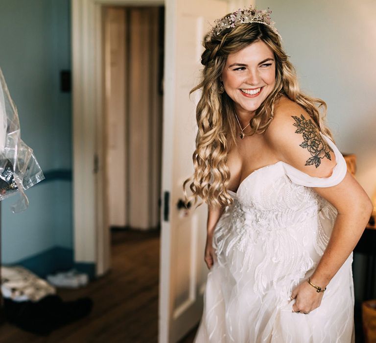 Bride getting ready on the morning of her wedding with crystal crown and off the shoulder wedding dress