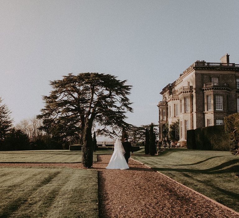 Bride and groom with full length white veil at Hedsor House wedding