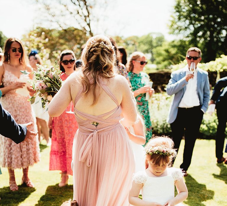 Bridesmaid in pink criss cross dress with flower girl and page boy 