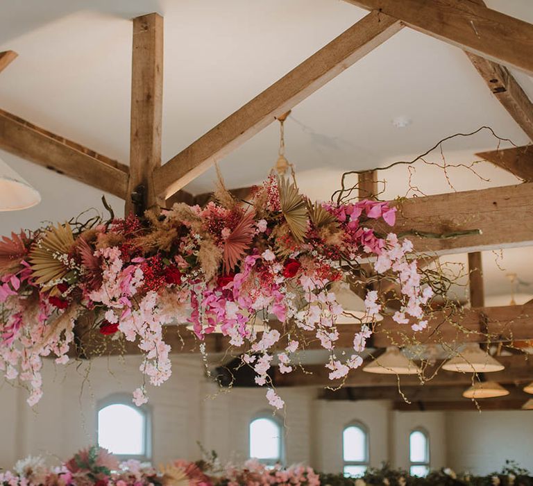 Prestwold Hall Barn exposed beams decorated in cherry blossom, dried grasses and pink flowers 