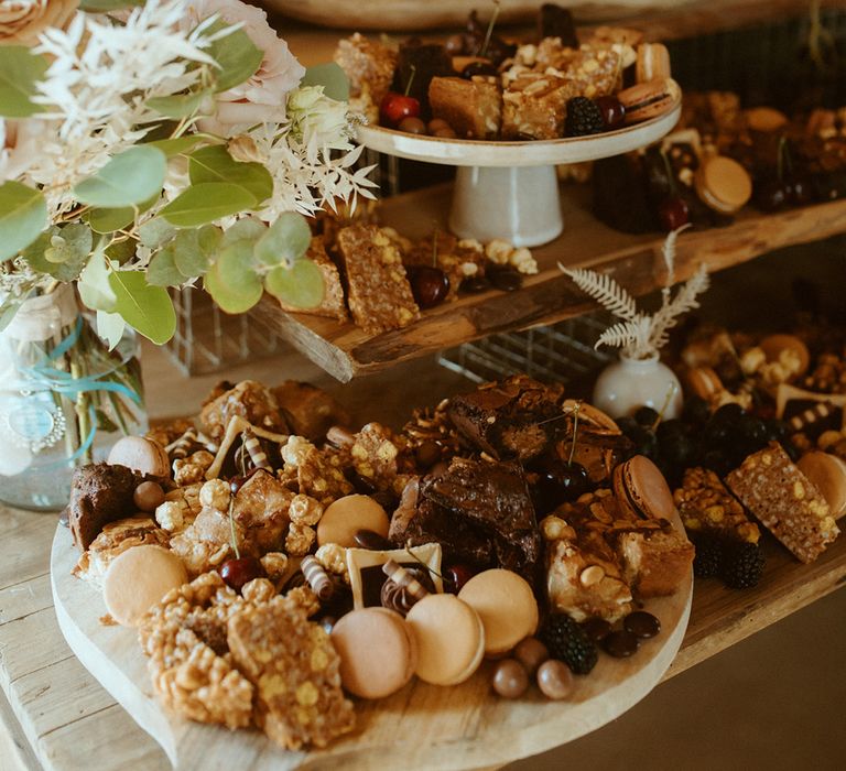 Grazing boards of sweet treats for dessert table with single tier buttercream frosted wedding cake 