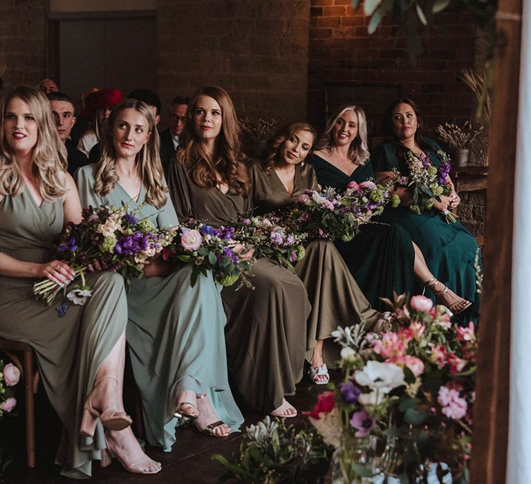 Bridesmaids in emerald, olive and sage green dresses in various styles for industrial spring wedding 