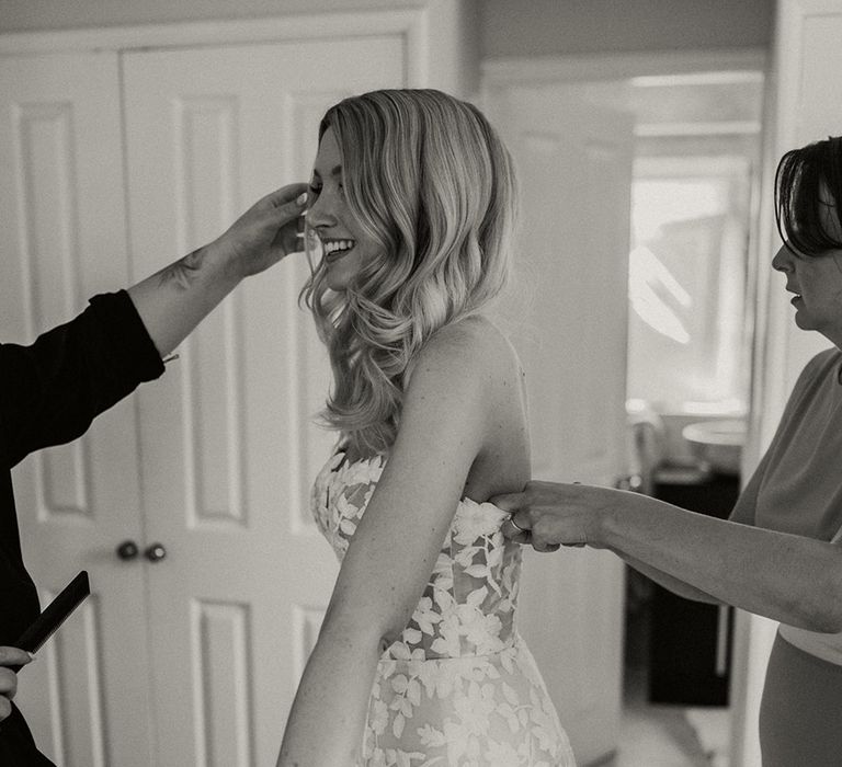 Bridal party help the bride with finishing touches for the big day 