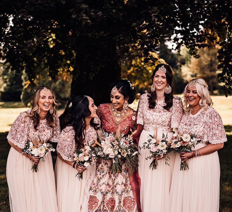 Bridesmaids wear Needle & Thread bridesmaid dresses in pale pink with floral embellished tops and polka dotted skirts 