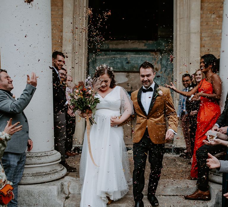 Bride and Groom exit chapel into autumnal themed confetti throw at London Wedding Venue