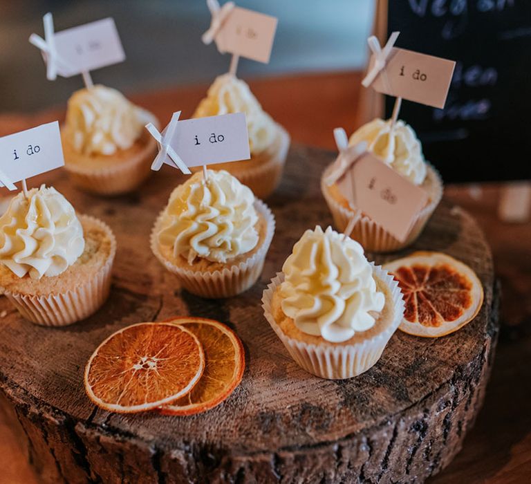 Gluten free vanilla cupcakes with frosting and mini topper reading 'I Do' 