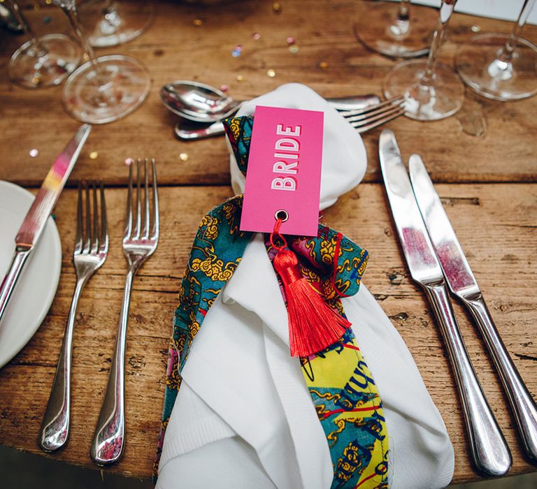 White napkin with tropical coloured lining and hot pink "bride" tag with red tassel 