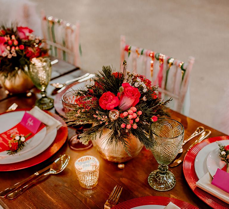 Wedding tablescape featuring gold vase centrepieces with rose, peony and dried flower arrangements with disco ball decorations, gold candleholders and colourful streamers on the back of chairs 