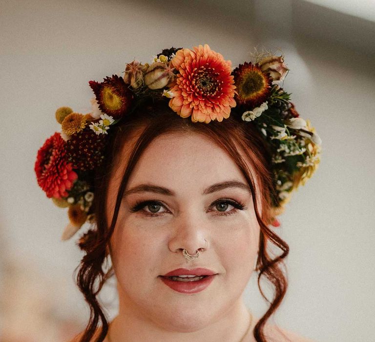 Bride in deep red and autumnal coloured bridal makeup look and boho rustic dried flower crown 