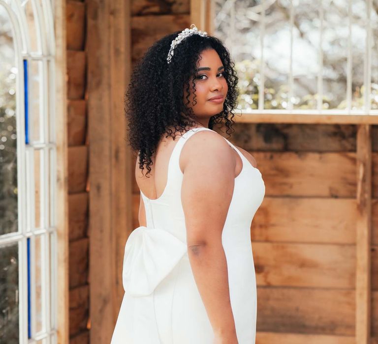 Bride in bow back satin wedding dress and silver bridal crown at Rackleys Barn wedding venue