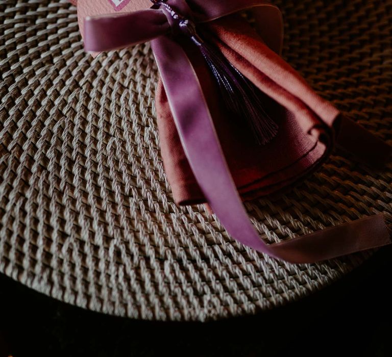 Dusky pink wedding napkin tied with purple ribbon and pink retro semicircular wedding place name 