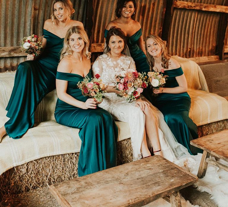 Rustic autumnal barn wedding with the bridesmaids in forest green gowns to reflect the fall season