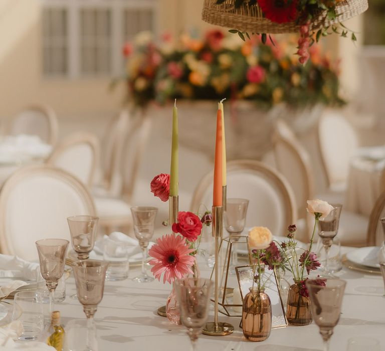 Croatia wedding reception decor with wicker lampshade, red and yellow gerbera flowers, and taper candles 