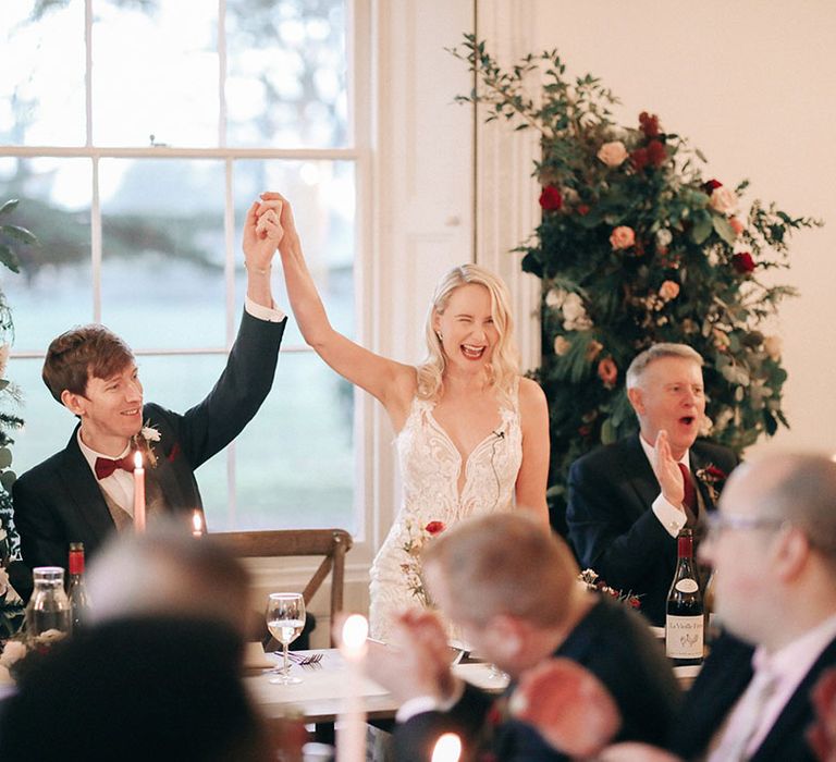 Red and white wedding flower columns decorating the reception space 