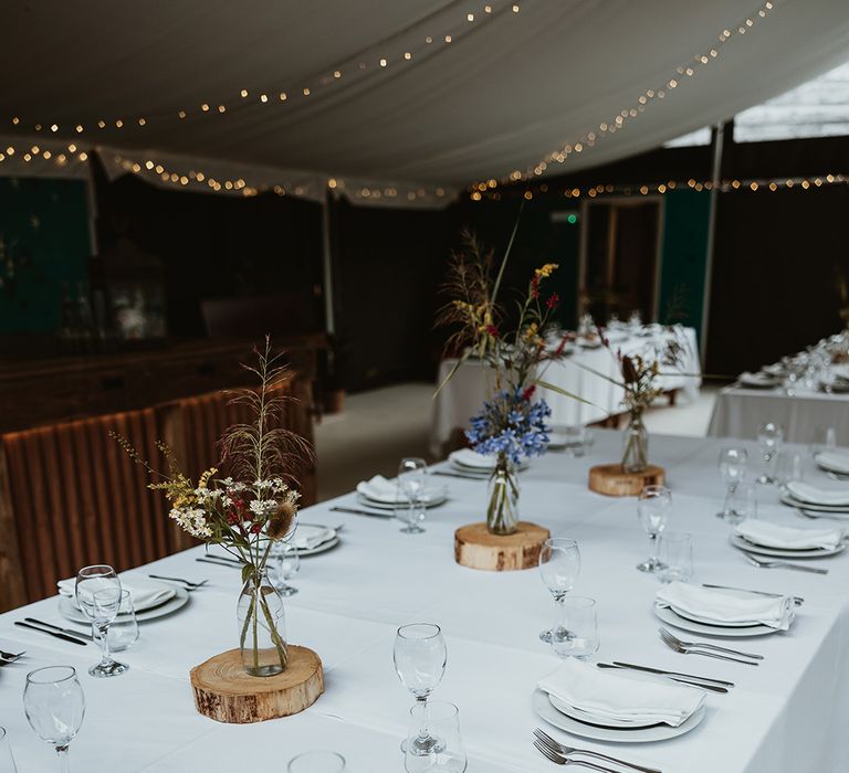 Simple minimalist wedding tablescape with rustic wood slice centrepieces and flowers 