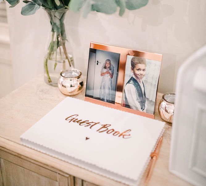 Wedding guest book with pictures of the bride and groom in copper frames 