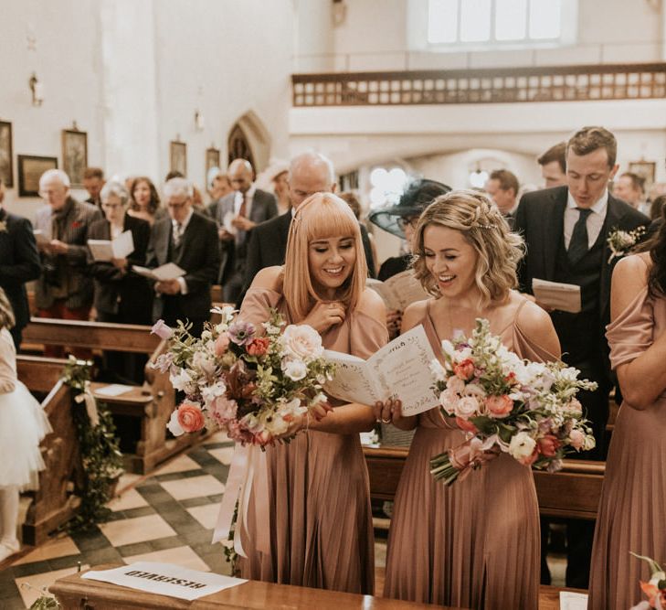 Bridesmaids in pink dresses inside the church 