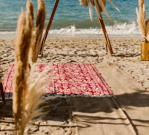 Boho beach wedding in Crete with triangle altar structure and pampas grass decor