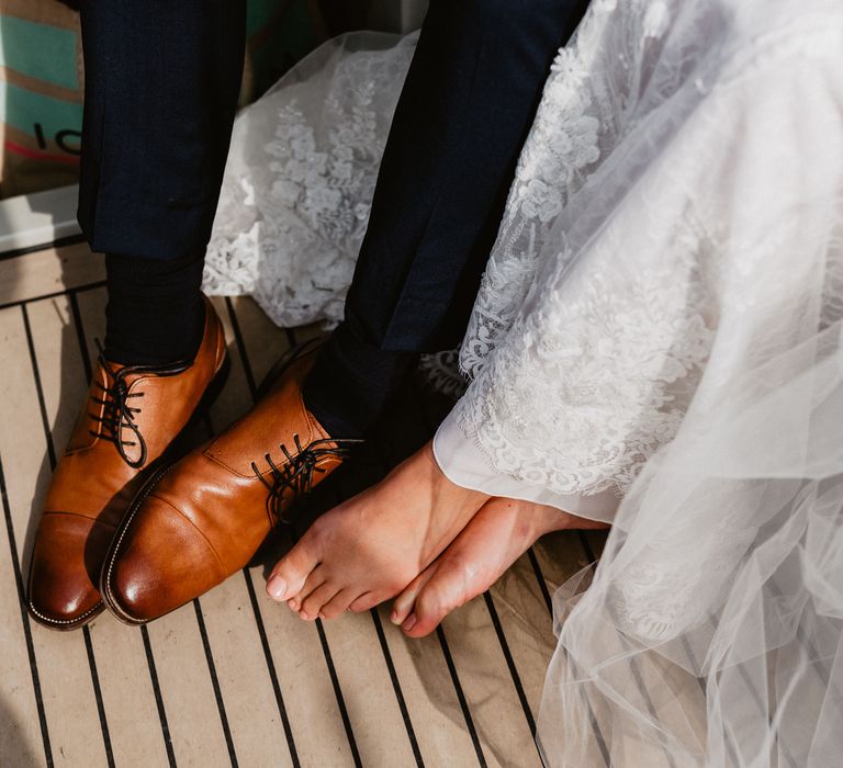 Bride & groom sit together on boat 