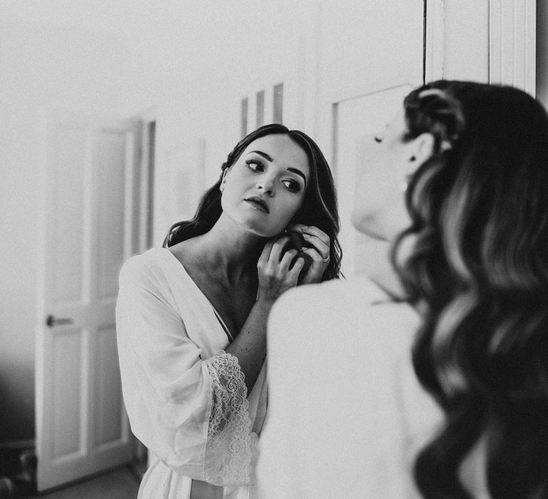 Bride puts earrings in getting ready for wedding ceremony