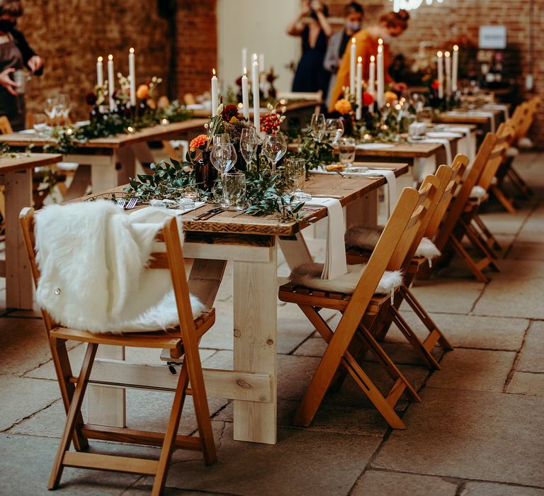 Rustic venue with wooden tables, hanging ivy and lighting 